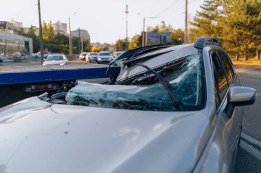 Otoyolda bir araba çarpıştı. Ciddi bir kaza. Yoldaki trafik kazaları. Kırık ön cam. Araba bir kamyonun karavanının altında uçtu. Trafik sıkışık. Sigorta davası yolda.