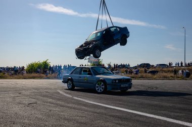 Bir yarış arabası hızlı bir şekilde sürüklenir. Sürücü arabayı sürüklüyor. Arka planda dumanla savrulan bir araba, dumanlı tekerlekler. Hız. Ekstrem spor. Yönlendirme. 