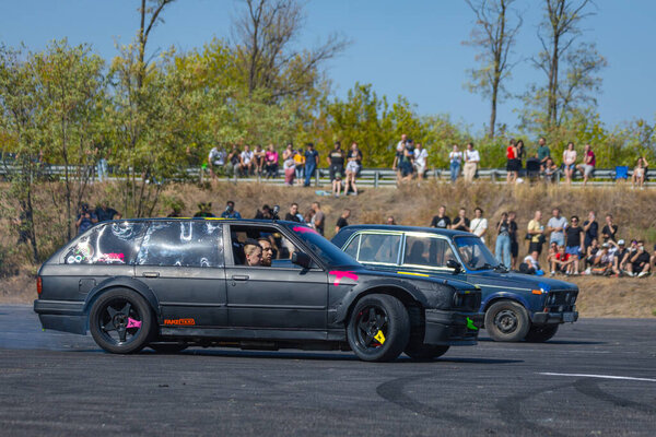 A racing car drifts on a fast track. The driver drifts the car. A car skidding against a background of smoke, smoking wheels. Speed. Extremesport. Route. 