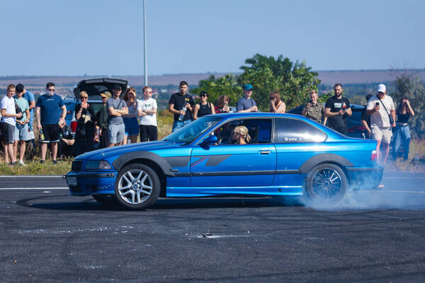 A racing car drifts on a fast track. The driver drifts the car. A car skidding against a background of smoke, smoking wheels. Speed. Extremesport. Route. 