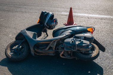 Motosiklet bir geziden sonra kaldırımda yatar. Ciddi bir kaza. Kaza, yakın planda. Kontrolü kaybettim ve düştüm. Araba kullanmanın tehlikeleri. Başka bir araca çarpmış..