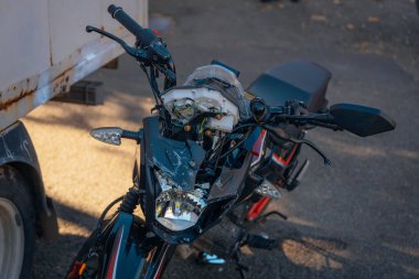 Motosiklet bir geziden sonra yolda duruyor. Ciddi bir kaza. Kaza, yakın planda. Kontrolü kaybettim ve düştüm. Araba kullanmanın tehlikeleri. Bir arabaya çarpmış. Araç.