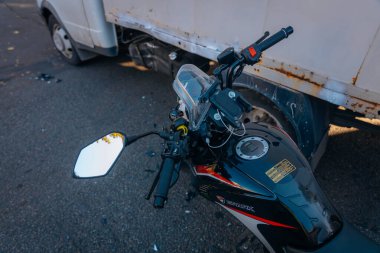 Motosiklet bir geziden sonra yolda duruyor. Ciddi bir kaza. Kaza, yakın planda. Kontrolü kaybettim ve düştüm. Araba kullanmanın tehlikeleri. Bir arabaya çarpmış. Araç.