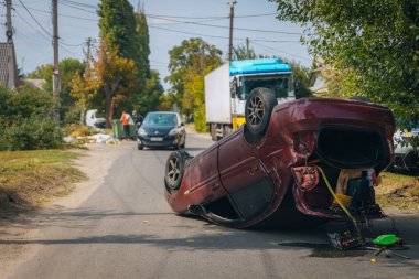 Trafik kazası. Otobanda devrilmiş bir araba. Arabada ağır hasar var. Detaylar, yakın plan. Araba yolda kaputun üzerinde yatıyor. Kontrolü kaybettim.