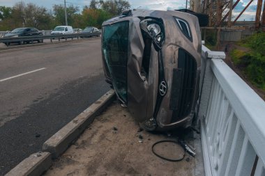 Trafik kazası. Otobanda devrilmiş bir araba. Arabada ağır hasar var. Detaylar, yakın plan. Araba yan yatar..