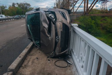 Trafik kazası. Otobanda devrilmiş bir araba. Arabada ağır hasar var. Detaylar, yakın plan. Araba yan yatar..