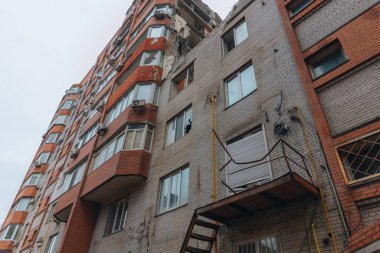 Russian missile hits residential building in Dnipro, Ukraine. Aftermath of enemy attack on city. Destroyed residential multi-story building. Close-up. War. Aftermath of explosion. clipart