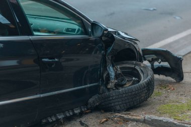 Arabadan bir tekerlek fırladı. Detaylar, yakın plan. Araba tekerleği. Ciddi bir kaza. Tekerleksiz araba yolda. Kontrolü kaybettim ve bir ağaca çarptım..