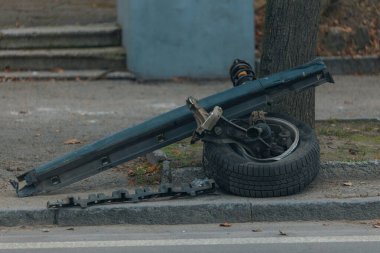Arabadan bir tekerlek fırladı. Detaylar, yakın plan. Araba tekerleği. Ciddi bir kaza. Tekerleksiz araba yolda. Kontrolü kaybettim ve bir ağaca çarptım..