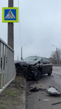 Bir direğe çarpma sonucu arabanın tamponu ve kaputu kırılmış. Araba bir lamba direğine çarptı. Trafik kazası. Yolcu vagonuna yakın çekim.