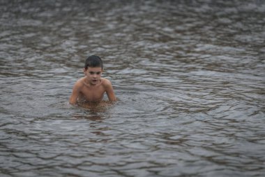 Ukrayna 'da kış tespihi. Epifani banyosu bir halk geleneğidir. Buzlu suya daldırmak. Ortodoks ayini buz deliğinde banyo yapmak. Birçok insan banyo yapar..