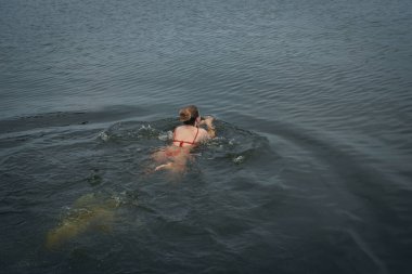 Ukrayna 'da kış tespihi. Epifani banyosu bir halk geleneğidir. Buzlu suya daldırmak. Ortodoks ayini buz deliğinde banyo yapmak. Birçok insan banyo yapar..