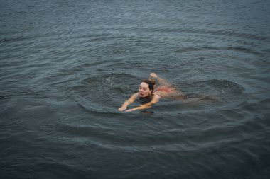 Ukrayna 'da kış tespihi. Epifani banyosu bir halk geleneğidir. Buzlu suya daldırmak. Ortodoks ayini buz deliğinde banyo yapmak. Birçok insan banyo yapar..