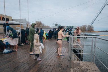 Ukrayna 'da kış tespihi. Epifani banyosu bir halk geleneğidir. Buzlu suya daldırmak. Ortodoks ayini buz deliğinde banyo yapmak. Birçok insan banyo yapar..