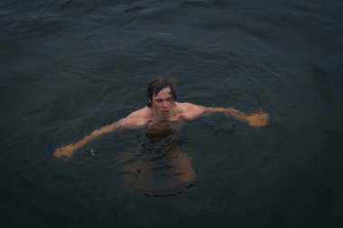 Ukrayna 'da kış tespihi. Epifani banyosu bir halk geleneğidir. Buzlu suya daldırmak. Ortodoks ayini buz deliğinde banyo yapmak. Birçok insan banyo yapar..