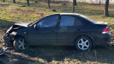 Yolun kenarındaki bir kazadan sonra araba, yakın plan. Ön tarafında ciddi hasar olan siyah bir araba kaza mahallinde. Yolun kenarındaki bir kazadan sonra araba. Kazaydı.