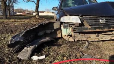 Yolun kenarındaki bir kazadan sonra araba, yakın plan. Ön tarafında ciddi hasar olan siyah bir araba kaza mahallinde. Yolun kenarındaki bir kazadan sonra araba. Kazaydı.