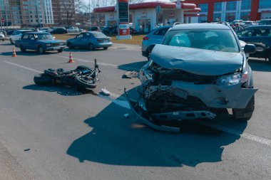 Kazadan sonra kaza yapmış bir motosiklet ve hasarlı bir araba, yakın plan. Yolda bir motosiklet ve ciddi hasar görmüş bir çapraz yol var. Çarpışmadan sonra....
