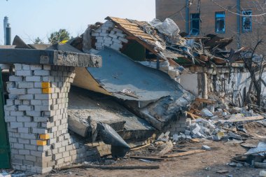 Askeri eylemlerin sonuçları, yıkılan bina, yakın plan. Duvarlarda, çatıda ve pencerelerde hasar var. Bir konut binasının yıkımı. Ukrayna 'da savaş. Sivillerin bombalanması.