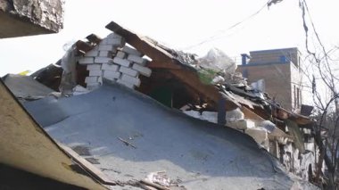 Askeri eylemlerin sonuçları, yıkılan bina, yakın plan. Duvarlarda, çatıda ve pencerelerde hasar var. Bir konut binasının yıkımı. Ukrayna 'da savaş. Sivillerin bombalanması.
