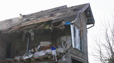 Askeri eylemlerin sonuçları, yıkılan bina, yakın plan. Duvarlarda, çatıda ve pencerelerde hasar var. Bir konut binasının yıkımı. Ukrayna 'da savaş. Sivillerin bombalanması.