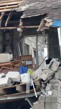 Askeri eylemlerin sonuçları, yıkılan bina, yakın plan. Duvarlarda, çatıda ve pencerelerde hasar var. Bir konut binasının yıkımı. Ukrayna 'da savaş. Sivillerin bombalanması.