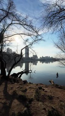 Cityscape with river and buildings reflected, panoramic view. Silhouettes of buildings are visible against the sky. Ukrainian city of Dnepr