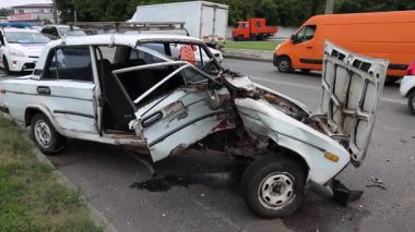 Şehir yolundaki bir trafik kazasından sonra, yakın plan. Ön tarafı kırık ve kaputu açık bir araba kaza yerinde. Kırık ön cam.