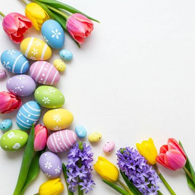 Paskalya yumurtaları ve bahar çiçekleriyle paskalya arkaplanı. Kopyalama alanı olan üst görünüm. Fotoğraf arkaplanı.
