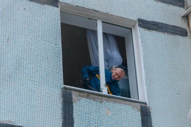 Ukrayna 'da bir konut binasının bombalanmasının sonuçları. Duvarlarda, çatıda ve pencerelerde hasar var. Bir konut binasının yıkımı. Bir yerleşim alanının bombalanması, siviller.