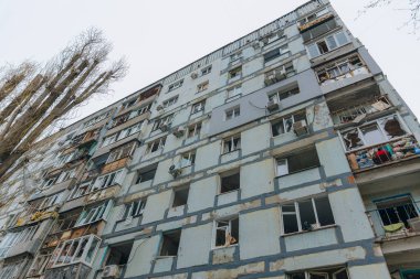 Ukrayna 'da bir konut binasının bombalanmasının sonuçları. Duvarlarda, çatıda ve pencerelerde hasar var. Bir konut binasının yıkımı. Bir yerleşim alanının bombalanması, siviller.