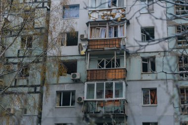 Ukrayna 'da bir konut binasının bombalanmasının sonuçları. Duvarlarda, çatıda ve pencerelerde hasar var. Bir konut binasının yıkımı. Bir yerleşim alanının bombalanması, siviller.