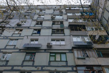 Ukrayna 'da bir konut binasının bombalanmasının sonuçları. Duvarlarda, çatıda ve pencerelerde hasar var. Bir konut binasının yıkımı. Bir yerleşim alanının bombalanması, siviller.