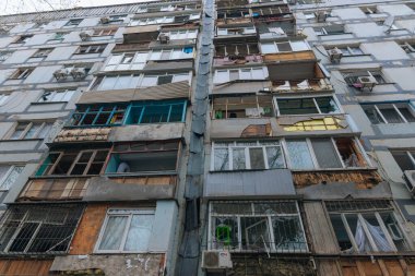 Ukrayna 'da bir konut binasının bombalanmasının sonuçları. Duvarlarda, çatıda ve pencerelerde hasar var. Bir konut binasının yıkımı. Bir yerleşim alanının bombalanması, siviller.