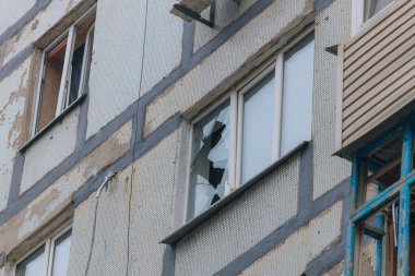 Ukrayna 'da bir konut binasının bombalanmasının sonuçları. Duvarlarda, çatıda ve pencerelerde hasar var. Bir konut binasının yıkımı. Bir yerleşim alanının bombalanması, siviller.