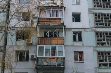 Ukrayna 'da bir konut binasının bombalanmasının sonuçları. Duvarlarda, çatıda ve pencerelerde hasar var. Bir konut binasının yıkımı. Bir yerleşim alanının bombalanması, siviller.