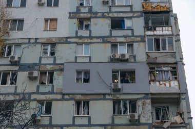 Ukrayna 'da bir konut binasının bombalanmasının sonuçları. Duvarlarda, çatıda ve pencerelerde hasar var. Bir konut binasının yıkımı. Bir yerleşim alanının bombalanması, siviller.
