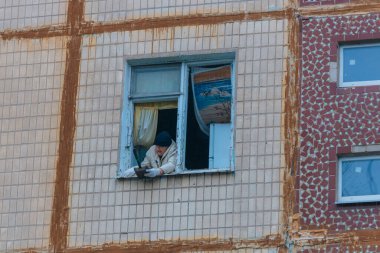 Ukrayna 'da bir konut binasının bombalanmasının sonuçları. Duvarlarda, çatıda ve pencerelerde hasar var. Bir konut binasının yıkımı. Bir yerleşim alanının bombalanması, siviller.