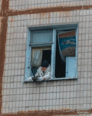 Ukrayna 'da bir konut binasının bombalanmasının sonuçları. Duvarlarda, çatıda ve pencerelerde hasar var. Bir konut binasının yıkımı. Bir yerleşim alanının bombalanması, siviller.