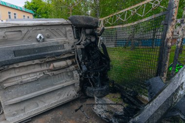 Devrilmiş bir araba yolun kenarında yan yatar. Bir araba kazasının olduğu yer. Arabada ciddi hasar var. Detaylar, yakın plan. Bir direğe çarpmış..