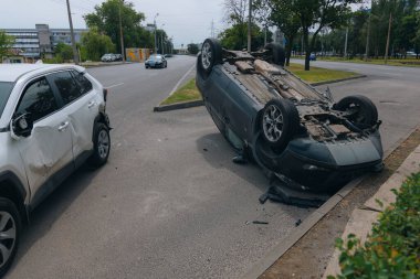 Olay yeri: Bir kazadan sonra yolun kenarında devrilmiş bir araba. Araba baş aşağı duruyor. Çarpışma sonrasını. Ayrıntıları kapat..