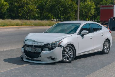 Ön tarafı ezilmiş bir araba, trafik kazasında hasar görmüş. Trafik kazası: çarpışma belirtileri olan bir araba. Çekilmeyi ya da onarılmayı bekliyor. Deforme olmuş kapüşonlu ve ön tamponlu bir araba..