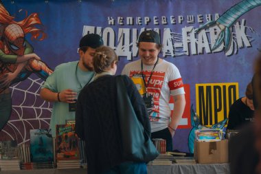 Kitapçıya ya ya da kitap fuarına gelip kitap seçiyor. Alışveriş ve okuma. Kütüphane. Kitap festivali. Kültürel etkinlik.