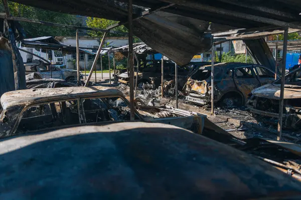 Kül ve çamur kaplı yanmış cesetlerde bükülmüş metal ve erimiş yapılar görülüyor. Arabanın içi mahvolmuş. Askeri çatışma ve bombardıman sonucu. Yıkılmış otopark.