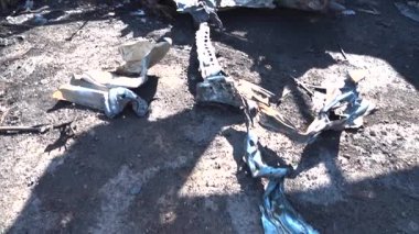 Kül ve çamur kaplı yanmış cesetlerde bükülmüş metal ve erimiş yapılar görülüyor. Arabanın içi mahvolmuş. Askeri çatışma ve bombardıman sonucu. Yıkılmış otopark.