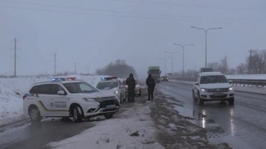 Şiddetli kar yağışı / kar fırtınası / buz ve zorlu yol koşulları nedeniyle polis tarafından kapatıldı. Parlayan ışıkları olan polis arabası.