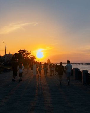 Ukrayna 'nın Dnipro şehrinde büyüleyici bir günbatımı. Günbatımı, şehir hayatı, toprak seti, eğlence, seyahat ve romantizm kavramı. Akşam yürüyüşü. Doğada aktif eğlence.