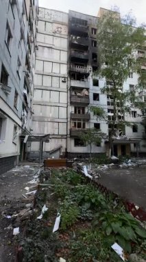 A damaged residential building with burnt-out balconies after shelling or fire. Broken windows and collapsed balcony structures are visible, the consequences of a conflict of damage.
