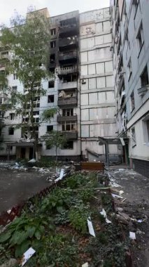 A damaged residential building with burnt-out balconies after shelling or fire. Broken windows and collapsed balcony structures are visible, the consequences of a conflict of damage.