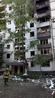 A damaged residential building with burnt-out balconies after shelling or fire. Broken windows and collapsed balcony structures are visible, the consequences of a conflict of damage.